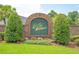 Elegant brick community sign surrounded by lush landscaping and vibrant flowers at 875 Bentley Green Cir, Winter Springs, FL 32708
