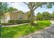 Charming house exterior showcasing manicured lawn, mature trees, and a side-entry garage at 875 Bentley Green Cir, Winter Springs, FL 32708