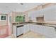 Bright kitchen featuring white cabinets, granite countertops and a large window with views of the lush backyard at 875 Bentley Green Cir, Winter Springs, FL 32708