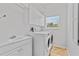 Well-lit laundry room with washer, dryer, sink, and storage cabinets at 875 Bentley Green Cir, Winter Springs, FL 32708