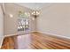 Well-lit living room boasts pristine wood floors, chandelier, and large windows, creating a welcoming ambiance at 875 Bentley Green Cir, Winter Springs, FL 32708