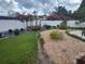 Spacious backyard boasts lush green grass, wooden rest area, rock bed and clean white fence at 8850 Pine Bay Ct, Orlando, FL 32825