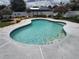 Inviting backyard swimming pool surrounded by a concrete deck and lush landscaping at 8850 Pine Bay Ct, Orlando, FL 32825