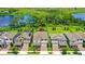 Aerial view of a home with a beautiful lake view, lush landscaping, and a pool with a spa in a well-maintained community at 9068 Sonoma Coast Dr, Winter Garden, FL 34787