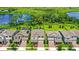 Aerial view of a home with a beautiful lake view, lush landscaping, and a pool with a spa in a well-maintained community at 9068 Sonoma Coast Dr, Winter Garden, FL 34787