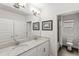 Bathroom featuring double sink vanity with granite countertop and framed mirrors at 9068 Sonoma Coast Dr, Winter Garden, FL 34787