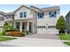 Charming two-story home features a manicured lawn, brick driveway, and a two-car garage at 9068 Sonoma Coast Dr, Winter Garden, FL 34787