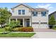 Charming two-story home features a manicured lawn, brick driveway, and a two-car garage at 9068 Sonoma Coast Dr, Winter Garden, FL 34787