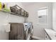 Well-organized laundry room with modern washer/dryer and convenient shelving for storage at 9068 Sonoma Coast Dr, Winter Garden, FL 34787