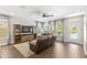 Comfortable living room with a leather couch, a ceiling fan and natural light at 9068 Sonoma Coast Dr, Winter Garden, FL 34787