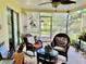 Relaxing screened porch with comfortable wicker furniture, ceiling fan, and view of the backyard, perfect for outdoor living at 1025 Sullivan St, Deltona, FL 32725