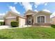 Inviting single-story home with manicured lawn, beige exterior and brick accents at 1021 Jaybee Ave, Davenport, FL 33897
