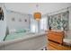 Stylized bedroom features white furniture, decorative wall hangings, light pendant, bamboo flooring, and bright natural light at 1061 Providence Ln, Oviedo, FL 32765