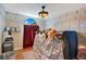 A bedroom featuring hardwood floors, playful wallpaper, ceiling fan, and a lofted bed with many stuffed animals at 1061 Providence Ln, Oviedo, FL 32765