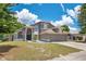 Two-story home with attached garage, well-manicured lawn, and mature trees at 1061 Providence Ln, Oviedo, FL 32765