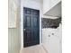 Well-lit laundry room boasts modern appliances, black accent door, white wood walls, and modern patterned wallpaper at 1061 Providence Ln, Oviedo, FL 32765