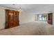 Living room with carpet, built-in shelving, and balcony overlooking lake at 1100 S Orlando Ave # 206, Maitland, FL 32751