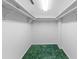 This walk-in closet features upper shelving and green carpet at 1100 S Orlando Ave # 206, Maitland, FL 32751