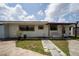 Backyard featuring a white bench, small plants, and a well-kept lawn at 1105 Arrowsmith Ave, Orlando, FL 32809