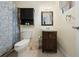 Bathroom with a blue shower curtain, dark vanity, toilet and decorative accessories at 1105 Arrowsmith Ave, Orlando, FL 32809