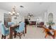 Open dining area with modern table set, chandelier, and a view of the living room at 1105 Arrowsmith Ave, Orlando, FL 32809