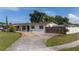 Single-story home featuring well-manicured lawn, mature landscaping, and gated driveway at 1105 Arrowsmith Ave, Orlando, FL 32809