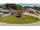 Single-story home featuring well-manicured lawn, mature landscaping, and circular driveway at 1105 Arrowsmith Ave, Orlando, FL 32809