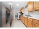 Galley kitchen featuring stainless steel appliances, bright white countertops, and wood cabinets at 1105 Arrowsmith Ave, Orlando, FL 32809