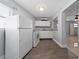 Bright open kitchen with white appliances, white cabinets, vinyl floors and a pass through at 1105 Arrowsmith Ave, Orlando, FL 32809