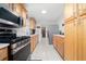 Galley style kitchen features stainless steel appliances and light wood cabinets at 1105 Arrowsmith Ave, Orlando, FL 32809