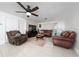 Bright living room with leather furniture, ceiling fan, and brick accent wall with television at 1105 Arrowsmith Ave, Orlando, FL 32809