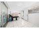 Bright room with white tiled floor and a massage table and shelving, with a sliding glass door at 1105 Arrowsmith Ave, Orlando, FL 32809