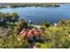 Breathtaking aerial view of a large house with a red tile roof, surrounded by trees, with lake views at 1351 N Classic Ct, Longwood, FL 32779