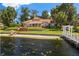Expansive backyard with a lakefront view, sandy beach, private dock, and lush landscaping at 1351 N Classic Ct, Longwood, FL 32779