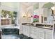 Elegant bathroom featuring a soaking tub, dual sinks, marble countertops, and verdant views from the large window at 1351 N Classic Ct, Longwood, FL 32779