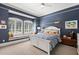 Comfortable blue bedroom features a window seat, patterned bedding, carpet floors, and ample sunlight at 1351 N Classic Ct, Longwood, FL 32779
