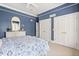 Blue bedroom with white trim features carpet floors, and a white dresser under an arched mirror at 1351 N Classic Ct, Longwood, FL 32779
