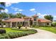 Stately home with a tile roof, manicured landscaping, and a circular driveway, exuding curb appeal at 1351 N Classic Ct, Longwood, FL 32779