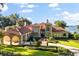 Beautiful two-story home featuring a grand entrance, lush landscaping, porte-cochere and lake views at 1351 N Classic Ct, Longwood, FL 32779