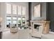 Bright living room featuring tall windows with lake view, elegant decor, and a striking fireplace at 1351 N Classic Ct, Longwood, FL 32779