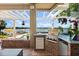 This outdoor kitchen features brick accents, a built-in grill, and views of the pool and lake at 1351 N Classic Ct, Longwood, FL 32779