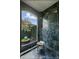 Shower with marble tile and a window view of the outdoor garden at 1351 N Classic Ct, Longwood, FL 32779