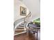 Elegant curved staircase with wood treads and wrought iron railing, accompanied by a grand piano at 1351 N Classic Ct, Longwood, FL 32779