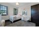 Bright bedroom featuring black door, plush chair, and accent wall decor at 1517 Edenhall Pt, Lake Mary, FL 32746