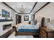 Elegant bedroom boasts a brick accent wall, fireplace, chandelier and a decorative tray ceiling at 1517 Edenhall Pt, Lake Mary, FL 32746
