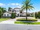 Beautiful Mediterranean-style home with mature landscaping, circular driveway, and a prominent palm tree at 1517 Edenhall Pt, Lake Mary, FL 32746