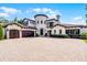 Expansive Mediterranean home featuring a three-car garage, brick driveway and elegant architectural details at 1517 Edenhall Pt, Lake Mary, FL 32746
