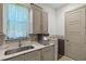 Well-appointed laundry area with sink, modern cabinetry, and marble countertops at 1517 Edenhall Pt, Lake Mary, FL 32746