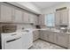 Bright laundry room featuring white cabinetry, marble countertops, and modern appliances at 1517 Edenhall Pt, Lake Mary, FL 32746