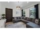 Cozy living room with a gray sectional sofa, dark door, and large windows at 1517 Edenhall Pt, Lake Mary, FL 32746